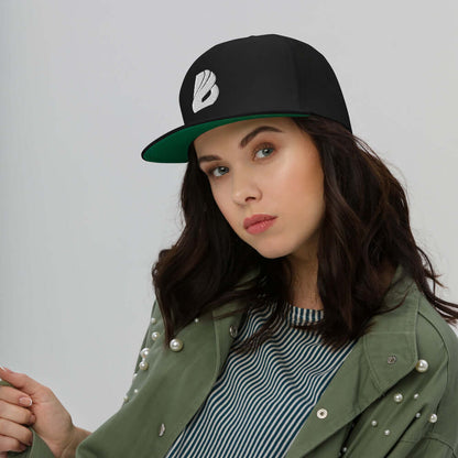 Model wearing Flat Bill-Cap N°1 with green under visor, structured 5-panel design, high-profile fit, and snapback closure.