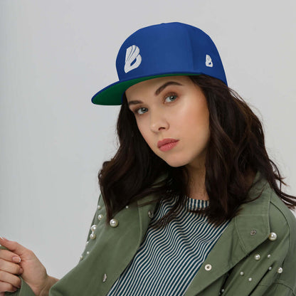 Woman wearing Flat Bill-Cap N°0 with green under-visor and 100% cotton cord fabric, styled with pearl-studded jacket.
