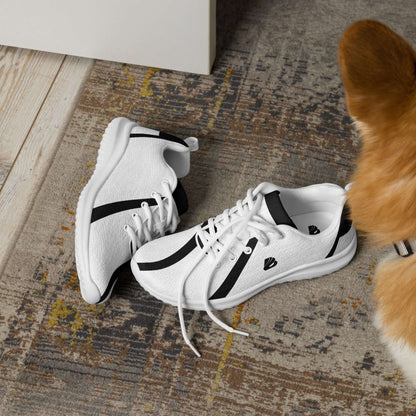 Herren-Turnschuhe N°0 auf Teppich neben Hund, weißes Flyknit-Material, EVA-Gummisohle, atmungsaktives Futter