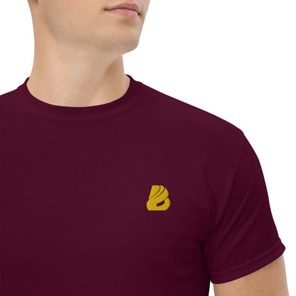 Stylish model wearing Klassisches Herren-T-Shirt N°0 in maroon with a gold logo on the chest, made from 100% cotton for a structured look.