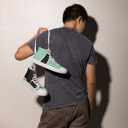 Man holding High-Top Leinenschuhe für Herren N°1 shoes over shoulder, stylish mint green and black design, casual fashion footwear.