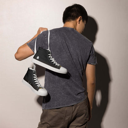 Mann mit High-Top Leinenschuhe für Herren N°3 auf der Schulter, schwarze Schuhe, weiße Sohle, schnittiges Design, Aufpeppung für jedes Outfit.