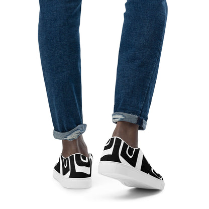 Person wearing Herren-Canvas-Slipper N°0 with black and white pattern, showing comfortable fit and stylish design.