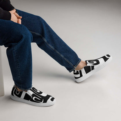 Model wearing black and white Herren-Canvas-Slipper N°0 shoes with rubber soles, styled for comfort and fashion.