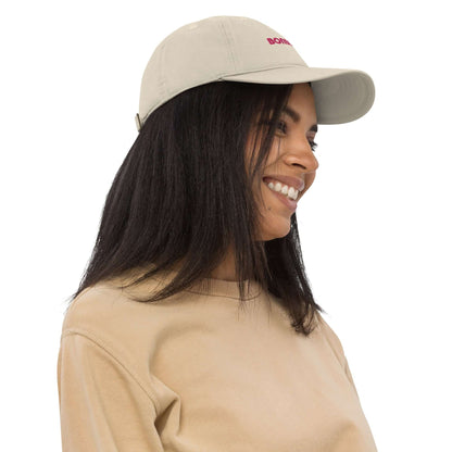 Smiling person wearing Bio-Dad Hat N°0 made from 100% organic cotton, showcasing sustainable fashion choice.