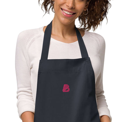 Model wearing Schürze aus Bio-Baumwolle N°0 with adjustable straps and front pocket, perfect for stylish cooking protection.