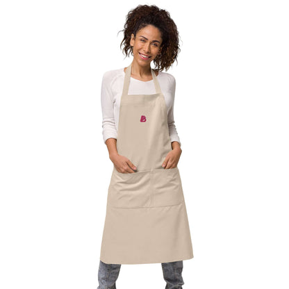 Woman wearing Schürze aus Bio-Baumwolle N°0 with adjustable straps and pocket, showcasing sustainable kitchen style.