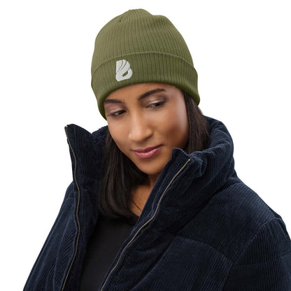 Frau trägt Gerippte Bio-Beanie N°0 aus 100 % organischer Baumwolle, atmungsaktiv, umweltfreundlich, in grünem Farbton, stilvoll und praktisch.