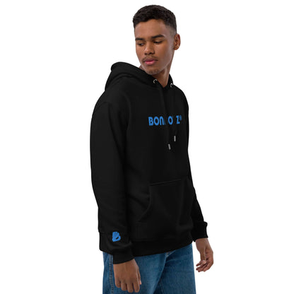 Hochwertiger Öko Kapuzenpullover N°7 in Schwarz mit blauer Aufschrift, doppellagiger Kapuze und Beuteltasche, getragen von Model