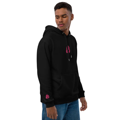 Man wearing Hochwertiger Öko Kapuzenpullover N°8 in black with pink logo, featuring front pouch and double-layered hood, eco-friendly materials.