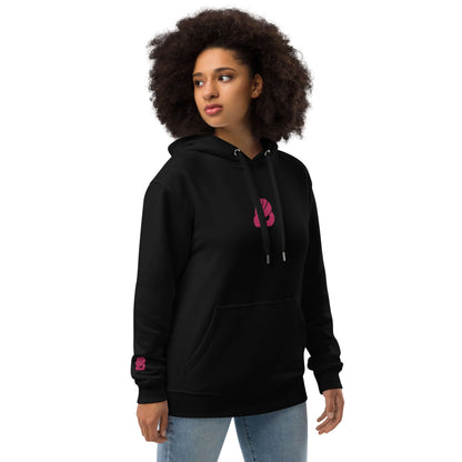 Woman wearing Hochwertiger Öko Kapuzenpullover N°8 in black with pink logo, showcasing eco-friendly fashion.