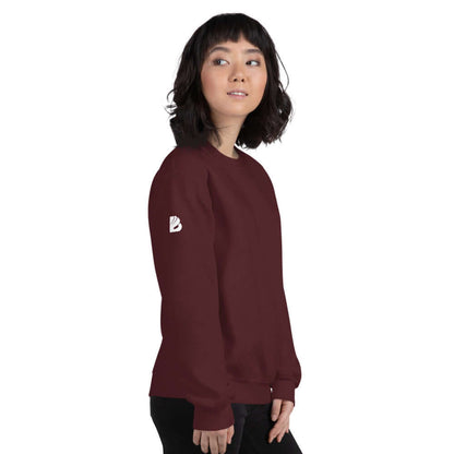 Woman wearing Unisex-Pullover N°5 in maroon, side view. Warm, classic fit sweater with logo on sleeve for cold months. Cotton and polyester blend.