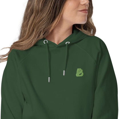 Woman wearing green Unisex Bio-Raglan-Hoodie N°0 with stylish logo, showcasing comfort and versatility