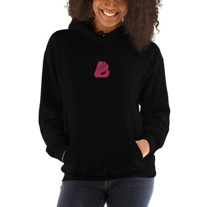 Woman wearing black Unisex-Kapuzenpullover N°44 with pink logo, cozy and stylish for cool evenings.
