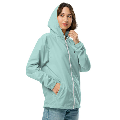 Model wearing Leichter Unisex-Windbreaker mit Reißverschluss N°0, light blue, waterproof hooded jacket, hands in pockets.