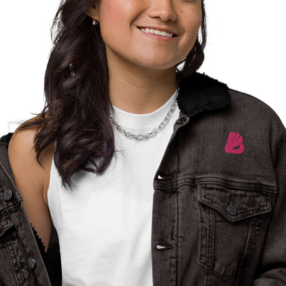 Unisex Sherpa Jeansjacke N°1 in black worn by smiling woman, showing soft sherpa lining for warmth and style.