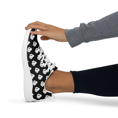 Person stretching foot wearing Damen-Turnschuhe N°0 with black and white pattern, showcasing breathable comfort and EVA rubber outsole.